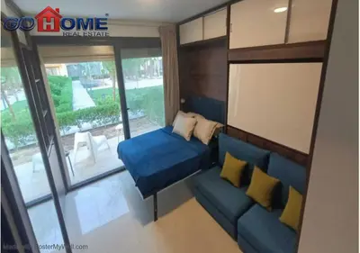 a living room with a blue couch and a large window at Cozy Studio 1BR G Cribs b19-g7 El-Gouna Shared Heatd Pool in El Gouna