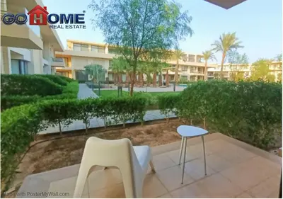a patio with two chairs and a table and a building at Cozy Studio 1BR G Cribs b19-g7 El-Gouna Shared Heatd Pool in El Gouna
