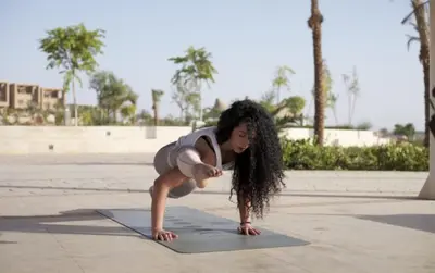 a woman doing a yoga pose on a yoga mat at MGM Wellness Retreat in Aswan
