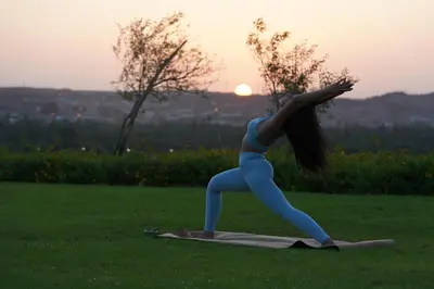 a woman doing a yoga pose in the grass at MGM Wellness Retreat in Aswan