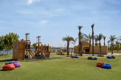 a playground with play equipment in a park with palm trees at MGM Wellness Retreat in Aswan