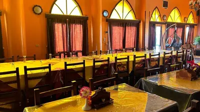 a room filled with tables and chairs with yellow table cloth at Cataract Nile View Rooms in Shellal