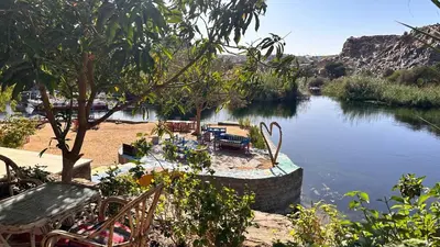a view of a river with tables and chairs at Cataract Nile View Rooms in Shellal
