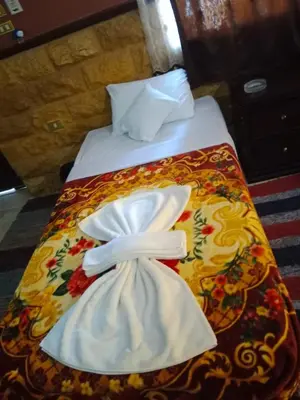 a bed with two white towels on top of it at Cataract Nile View Rooms in Shellal