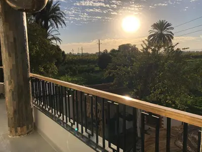 a view from a balcony with the sun in the sky at Villa Luna Simone in Al Karnak