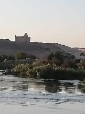 a painting of a river with a castle in the background at Nubia House Nile View in Nag` el-Ramla