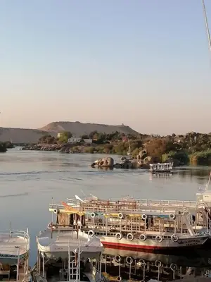 a boat is docked at a marina on a river at Nubia House Nile View in Nag` el-Ramla
