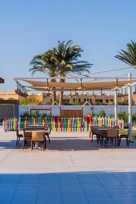 a group of tables and benches under a pavilion at Scandic sea view in Hurghada