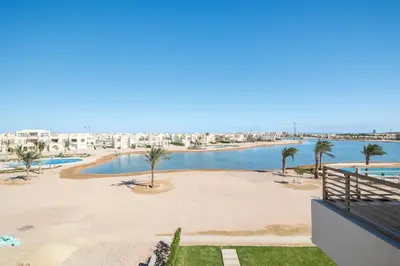a view of a beach with palm trees and buildings at Brand New Shedwan Spacious 1Bdr in Hurghada