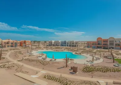 a resort with a swimming pool in a courtyard at Sophisticated 1BR 1,5 Bath Duplex - Kamaran El Gouna, Pool View & Access in Hurghada
