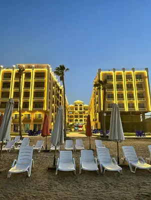 a group of lounge chairs and umbrellas on a beach at Seaview 2 Bedroom Private Deluxe Condo at Juliana Beach Resort B2-09 in Hurghada