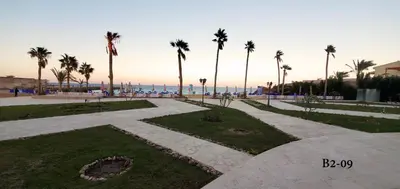 a park with palm trees and the ocean in the background at Seaview 2 Bedroom Private Deluxe Condo at Juliana Beach Resort B2-09 in Hurghada