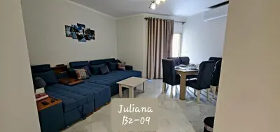 a living room with a blue couch and a table at Seaview 2 Bedroom Private Deluxe Condo at Juliana Beach Resort B2-09 in Hurghada