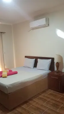 a bedroom with a bed with white sheets and a white air conditioner at Casablanca Resort A F in Hurghada