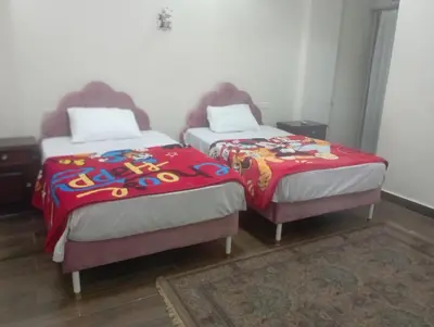 two beds with colorful blankets in a room at شقه على النيل in Luxor