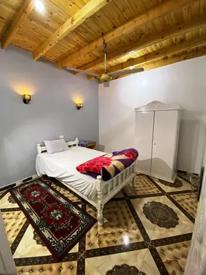 a bedroom with a bed and a tiled floor at Ammar Guest House in Luxor