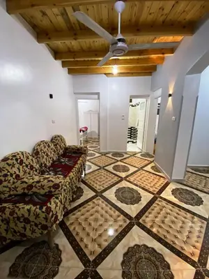 a living room with two chairs and a ceiling fan at Ammar Guest House in Luxor