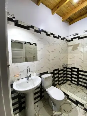 a bathroom with a white toilet and a sink at Ammar Guest House in Luxor