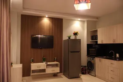 a kitchen with a refrigerator and a tv on the wall at Cosy studio Florenza khamsin in hurghada in Hurghada