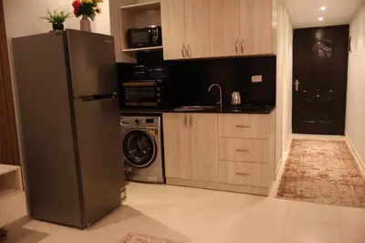 a kitchen with a refrigerator and a washer and dryer at Cosy studio Florenza khamsin in hurghada in Hurghada