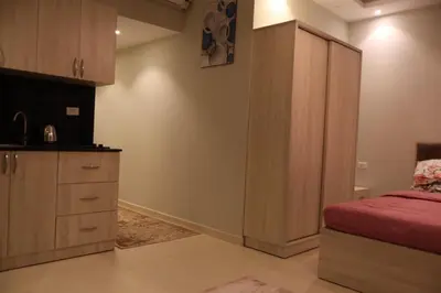 a bedroom with a bed and a cupboard with a red sheets at Cosy studio Florenza khamsin in hurghada in Hurghada