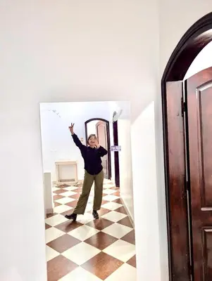 a man standing in a hallway with his arms in the air at Golden Rose Guesthouse in Luxor