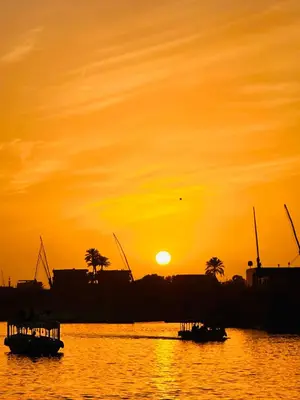 two boats in the water at sunset at Golden Rose Guesthouse in Luxor