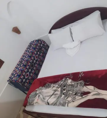 a bed with a picture of a woman on it at Old Nile Retreat in Luxor
