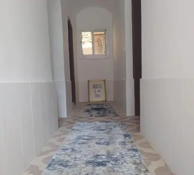 a hallway with a rug on the floor and a window at Old Nile Retreat in Luxor