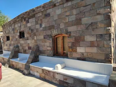 a brick wall with two benches on a patio at Old Nile Retreat in Luxor