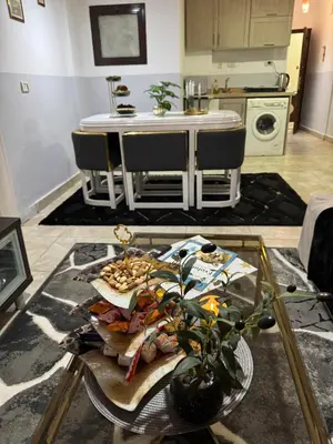 a living room with a table and a kitchen at Modernes Komfort mit Smart TV & Power W-LAN, Strandnähe in Hurghada in Hurghada