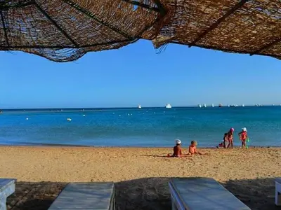 a group of people sitting on the beach at Andalus in in Hurghada