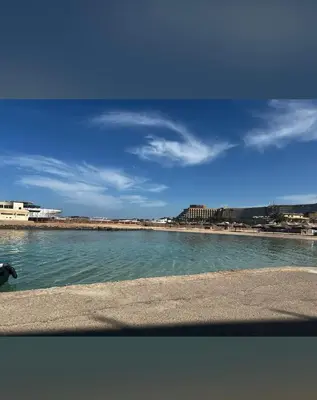a body of water with a beach in the background at Adler-Hurghada Holiday apartment sea view rooftop pool 80m to beach in Hurghada