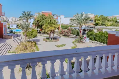 a balcony with a white railing and palm trees at Elaskary in Hurghada