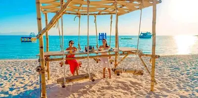 two women sitting at a table on the beach at Contesa Do in Hurghada