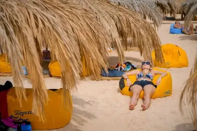 a woman laying on a raft on the beach at Contesa Do in Hurghada