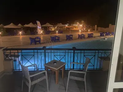 a view of a swimming pool at night with chairs and a table at vision suites Arbia Hurghada in Hurghada
