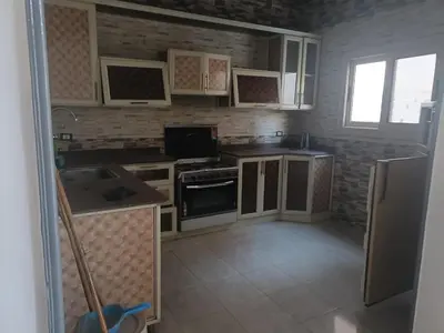 a kitchen with white cabinets and a stove top oven at Jamaica Dream in Luxor