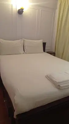 a white bed with white sheets and pillows on it at Jamaica Dream in Luxor