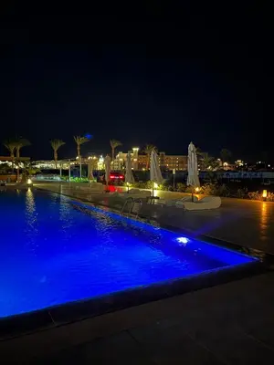 a large swimming pool at night with blue illumination at Scandic resort private beach in Hurghada