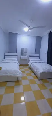 a room with two beds and a ceiling fan at شقة لاروز الغردقه الكوثر القديم شارع النور عماره لاروز in Hurghada