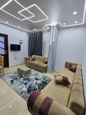a living room with a large couch and a living room with a tv at شقة لاروز الغردقه الكوثر القديم شارع النور عماره لاروز in Hurghada