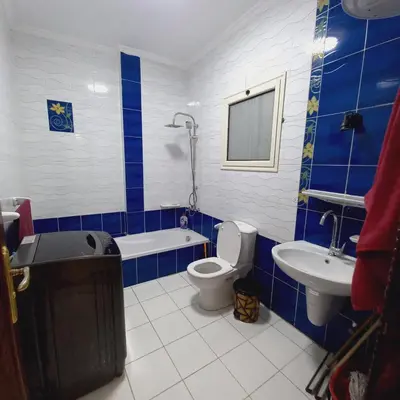 a blue and white bathroom with a toilet and a sink at شقة لاروز الغردقه الكوثر القديم شارع النور عماره لاروز in Hurghada