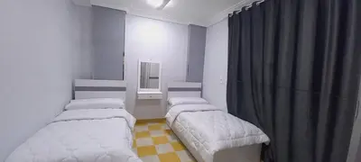 two beds in a small room with a curtain at Larose Apartment in Hurghada
