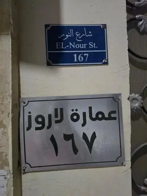a sign on the side of a wall with a sign in a foreign language at Larose Apartment in Hurghada