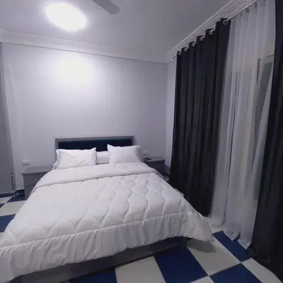 a bedroom with a white bed and a window at Larose Apartment in Hurghada