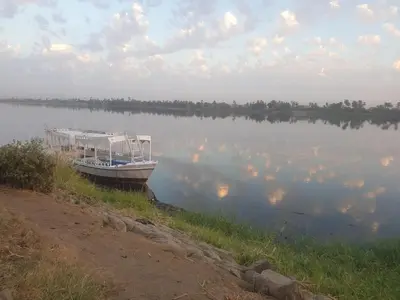 a boat sitting on the shore of a lake at Lucky Nile Tours in Luxor