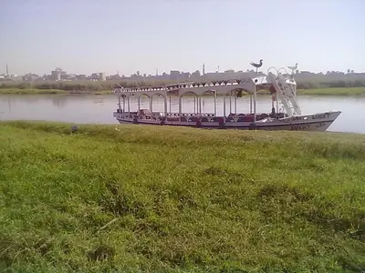 a boat sitting on the side of a river at Lucky Nile Tours in Luxor