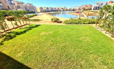a grassy area with a river and some buildings at Gouna -tawila in Hurghada