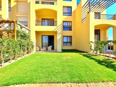 an apartment building with a lawn in front of it at Gouna -tawila in Hurghada